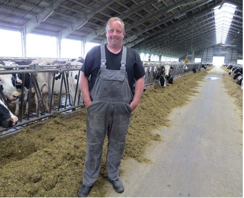  Jørn Friis Møller står i foran sine malkekvæg i stalden.